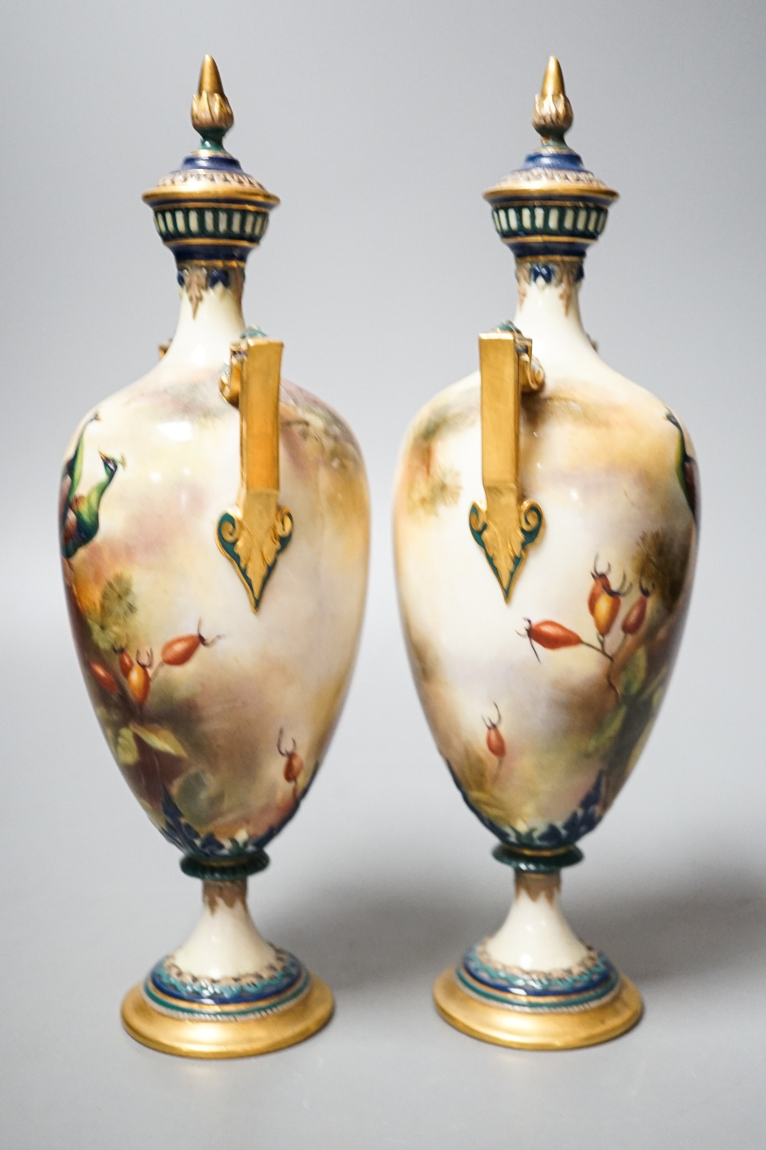 A pair of Royal Worcester Hadley ware Peacock vases and covers 24cm